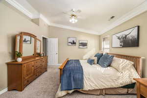Bedroom featuring crown molding, light colored carpet, vaulted ceiling, and a ceiling fan