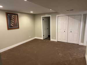 Unfurnished bedroom featuring colored carpet, recessed lighting, and a closet