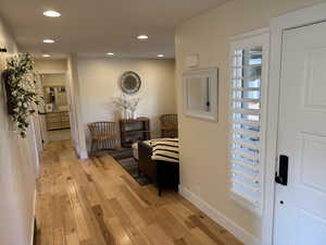 Corridor with light wood finished floors and recessed lighting
