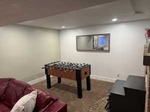 Playroom with a textured ceiling and carpet floors