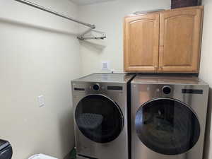 Laundry area featuring washing machine and dryer and cabinet space
