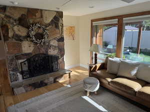 Living area with a fireplace, wood finished floors, and recessed lighting