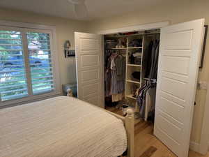 Bedroom with light wood finished floors, a closet, and a ceiling fan