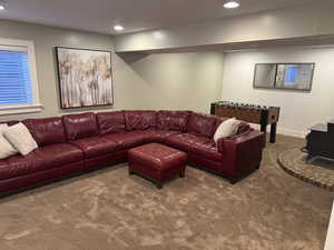 Carpeted living area with a wood stove and recessed lighting