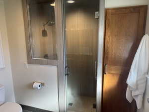 Bathroom featuring a shower stall and toilet