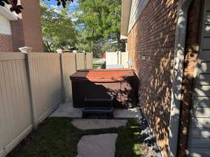 View of side of property featuring a hot tub and brick siding