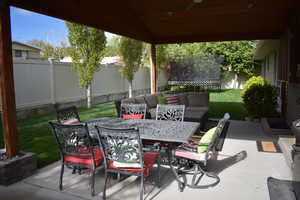 Fenced backyard featuring a patio, outdoor dining space, an outdoor hangout area, a trampoline, and ceiling fan