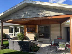Back of house with a patio and outdoor lounge area