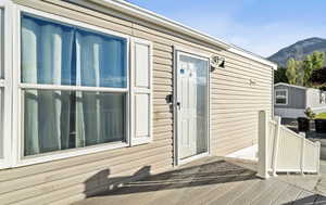 View of exterior entry featuring a deck with mountain view