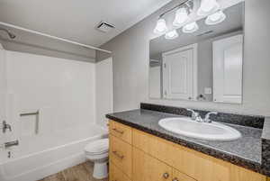 Full bath with shower / bath combination, vanity, and light wood-type flooring