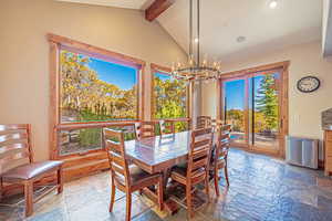 Dining space with a chandelier, plenty of natural light, stone tile floors, and recessed lighting