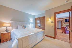 Bedroom with a fireplace and light carpet