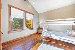Bedroom featuring wood finished floors, vaulted ceiling, and recessed lighting