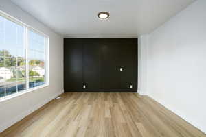 Unfurnished room with light wood-style floors and baseboards