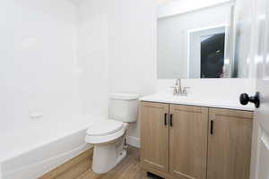 Bathroom featuring vanity, light wood finished floors, and bathtub / shower combination