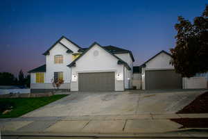 View of front facade with driveway and stucco siding