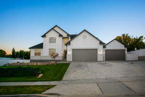 View of front of home with concrete driveway, stucco siding, and an attached garage