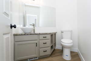 Half bathroom with vanity and light wood finished floors