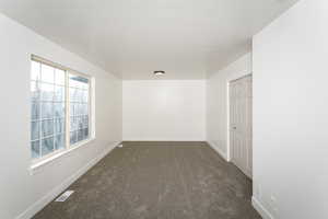 Unfurnished room with dark carpet