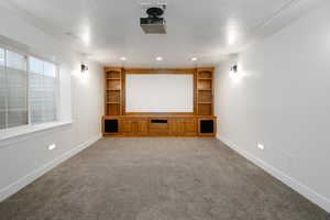 Cinema room with built in features, carpet, a textured ceiling, and recessed lighting