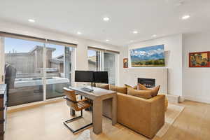 Media/family room area on level one; fireplace; view of deck with hot tub.