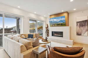 Living area featuring a limestone fireplace, light wood finished floors, and recessed lighting. Views of the new Sunrise Gondola in the distance.