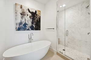 Primary en suite full bath with separate shower and soaking tub.