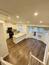 Kitchen featuring plenty of natural light, stainless steel appliances, white cabinets, light stone counters, and recessed lighting