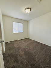 Spare room featuring carpet and a textured ceiling