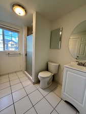Bathroom with vanity, light tile patterned floors, and a shower stall