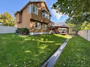 Back of house featuring a deck with mountain view, a fenced backyard, stucco siding, and stairs