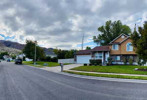 View of front of home featuring stone siding, stucco siding, concrete driveway, and an attached garage