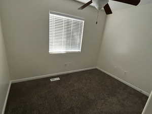 Unfurnished room featuring a textured ceiling and dark colored carpet