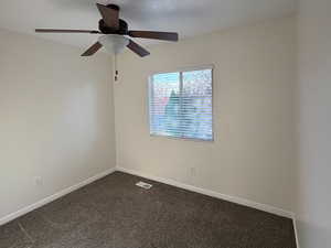 Bedroom #2: Spare room featuring dark colored carpet and baseboards