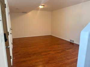 Living room featuring dark wood-style floors and baseboards