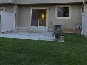 Back of property with stucco siding and a patio