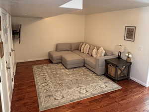 Living room with a textured ceiling and dark wood-style flooring