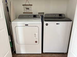 Laundry room with wood finished floors and independent washer and dryer