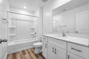 Bathroom with bathing tub / shower combination, vanity, and light wood finished floors
