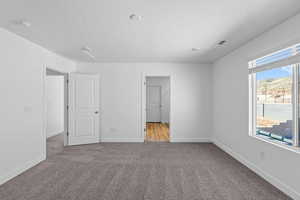 Unfurnished bedroom with carpet floors and a textured ceiling
