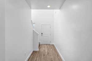 Hallway featuring light wood finished floors and stairs