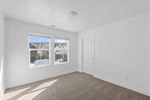 Carpeted spare room with baseboards