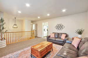 Living area with recessed lighting, carpet, and a chandelier