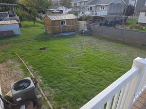 Fenced backyard with a shed and a residential view