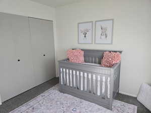 Bedroom featuring a crib and a closet