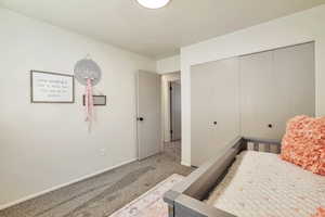 Bedroom featuring light colored carpet and a closet