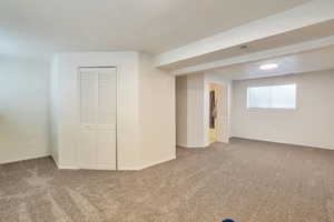 Basement featuring carpet and a textured ceiling