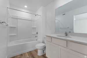 Bathroom featuring shower / washtub combination, light wood-style flooring, and vanity