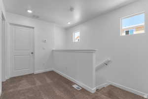 Spare room with dark carpet, a textured ceiling, and recessed lighting