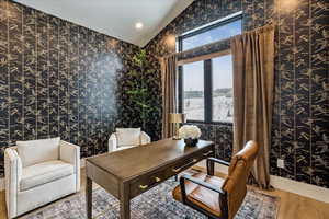 Office area featuring wallpapered walls, wood finished floors, recessed lighting, and vaulted ceiling